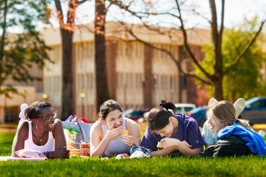 Four students study outside on ECU's campus