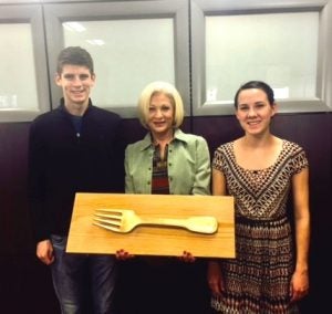 Honors College students, Joshua Spears and Madeline Tripp, present the "Golden Fork Award" to MSCM Chair Dr. Judy Siguaw.