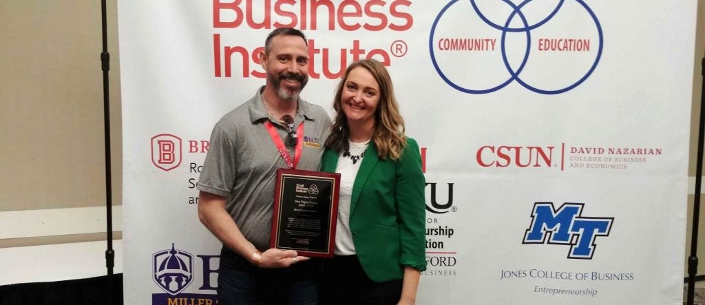 Dennis Barber and Whitney Peak pose with an award