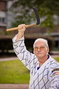 Doug Thomas, pictured, with martial arts weapon on ECU's campus