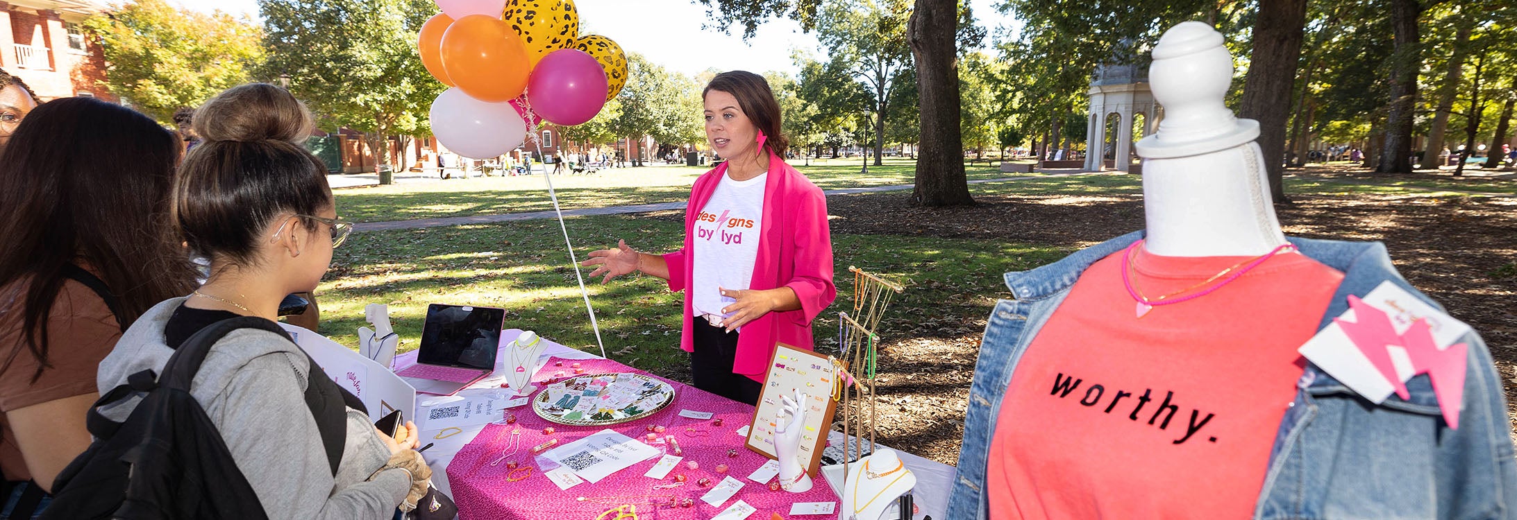 Student pitches her idea in an outside gallery of other entrepreneurs on the Campus of ECU