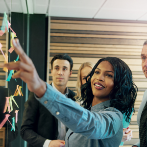 Women adding post-it notes to wall