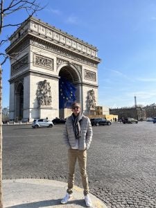 COB student stands in front of the Arc de Triomphe