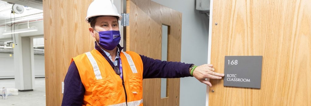 Dr. Mike Harris points to sign on door in the under-construction Isley Innovation Hub