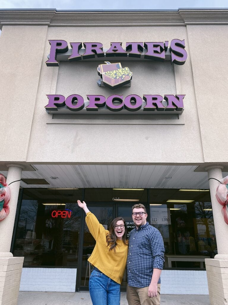 Erika Edmundson and husband stand outside pirate's popcorn.