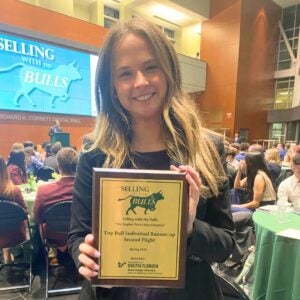 Olivia Grubb holds award while at sales competition