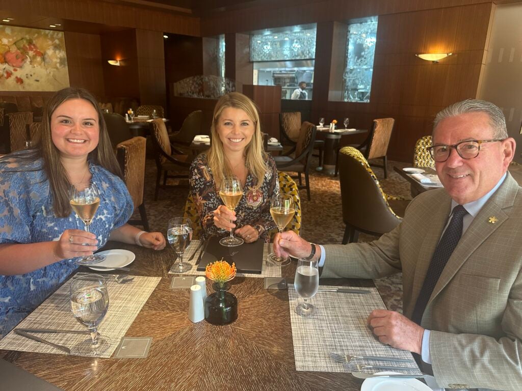 Maddy Mize sits with two other people in an upscale restaurant
