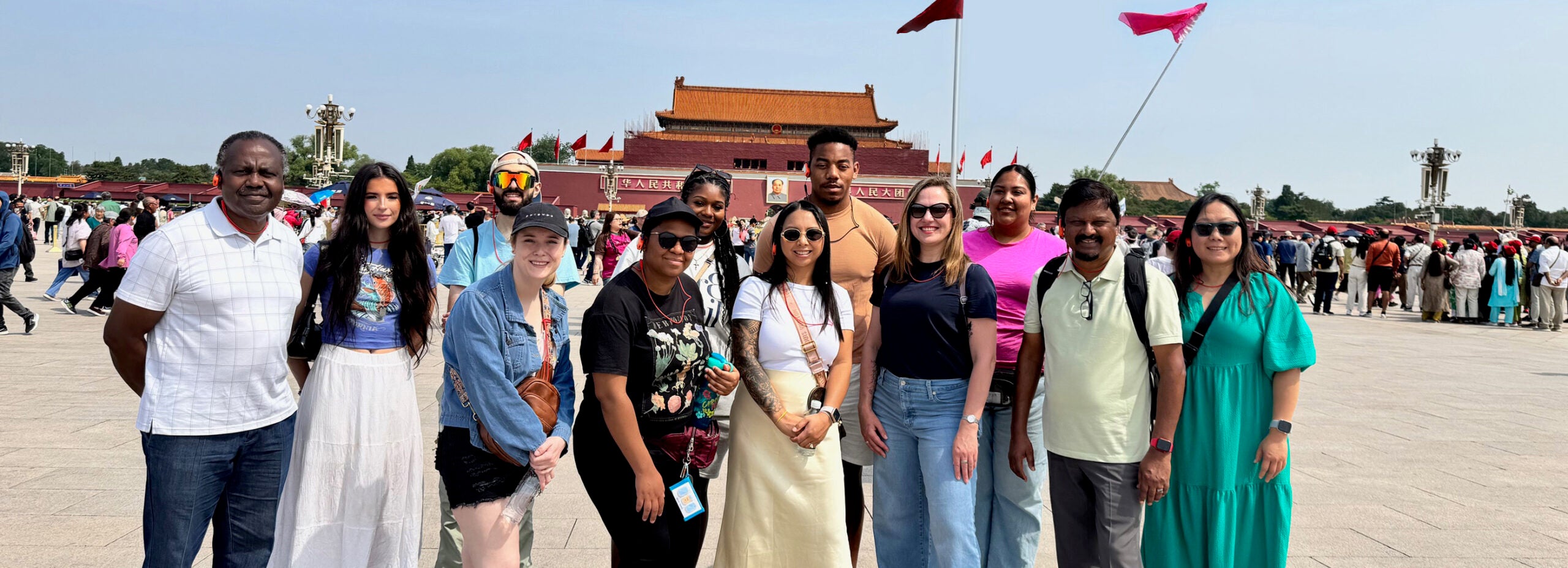 A group of young adults stand in front of an ancient temple.