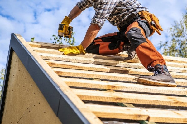 Construction worker on roof top of new construction