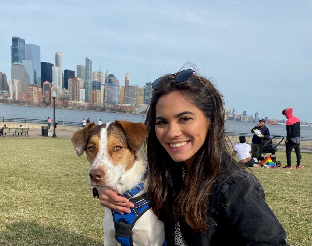 Jessica Gant and her dog with the city of Manhattan in the background.